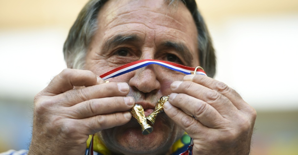 Torcedor francês beija miniaturas da taça da Copa do Mundo