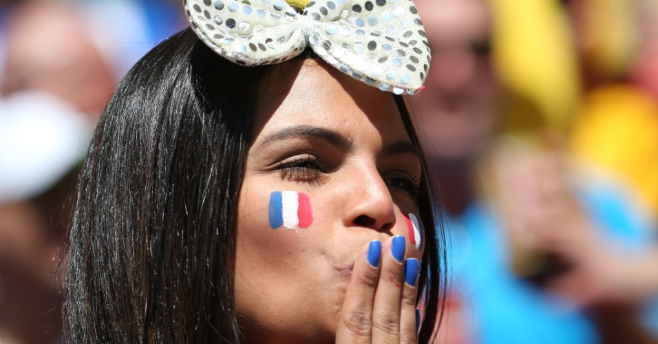 Torcedora francesa manda beijo na arquibancada do estádio Nacional antes do jogo entre França e Nigéria