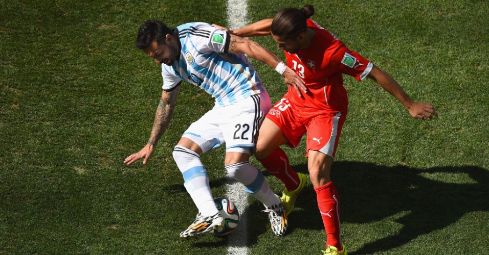 01.jul.2014 - Argentino Lavezzi disputa a bola com Ricardo Rodriguez, da Suíça, no início do jogo no Itaquerão, válido pelas oitavas de final