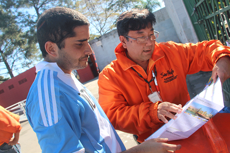 O funcionário da SPTuris Ricardo Higa ensina argentino a chegar à Fan Fest do Sambódromo e aprende portunhol