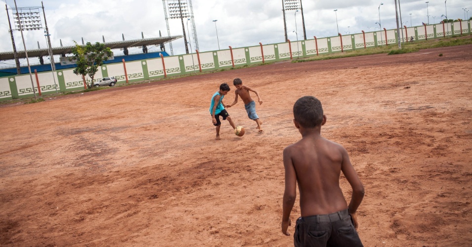 Crianças jogam bola em frente o estádio oficial do Amapá, o Zerão, que tem a linha do meio de campo como divisa para os dois hemisférios, cada lado do campo fica em um hemisfério
