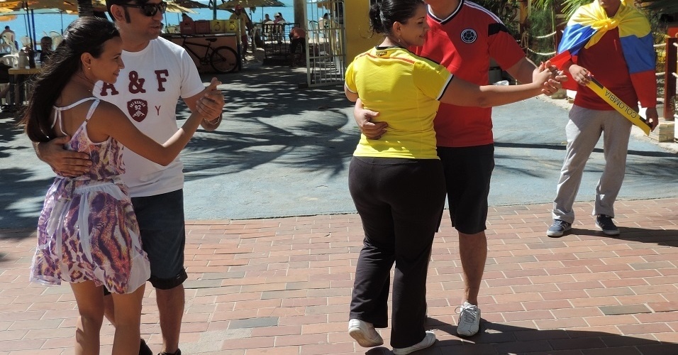 Casal de colombianos tenta aprender forró com brasileiros na orla de Fortaleza