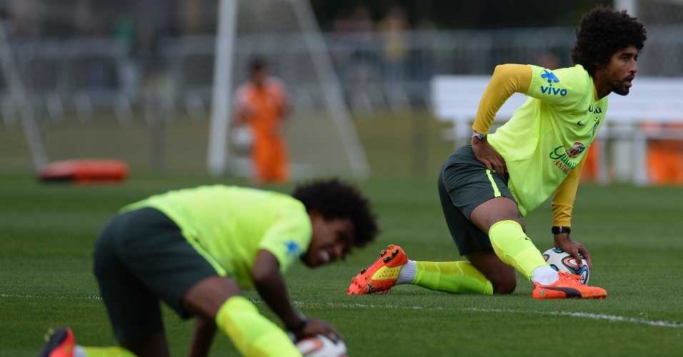 06.jul.2014 - Dante (ao fundo) e Willian fazem aquecimento antes de jogo treino dos reservas da seleção contra o time sub-20 do Fluminense