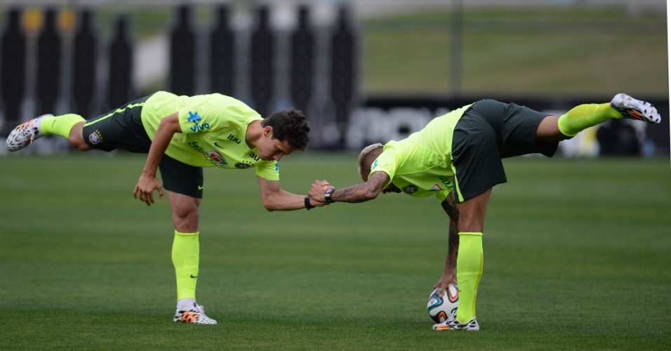 06.jul.2014 - Hernanes e Daniel Alves fazem aquecimento antes de treino da seleção