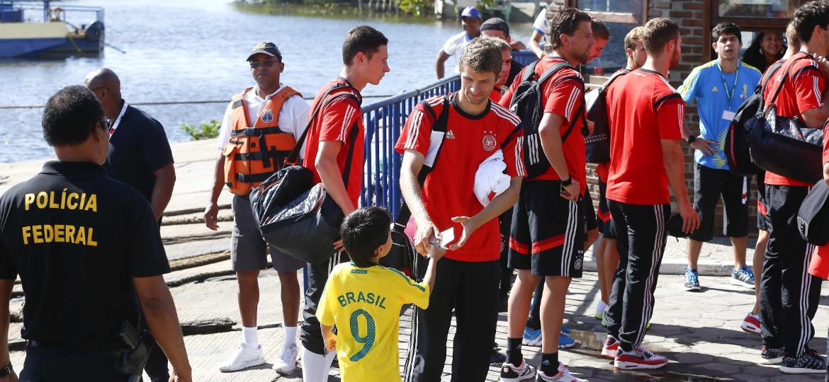 Thomas Müller dá autógrafo para criança com a camisa do Brasil na saída da Alemanha de Cabrália, em 2014 - Arnd Wiegmann/Reuters