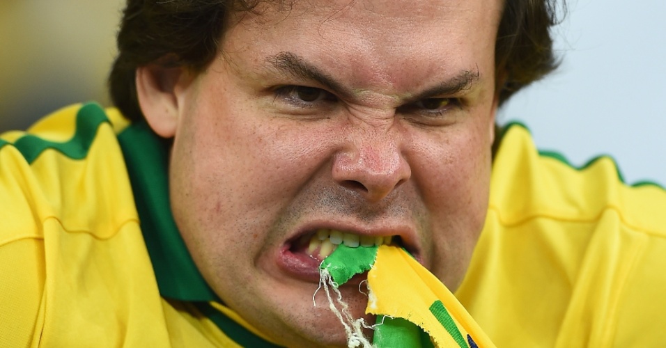 08. jul. 2014 - O torcedor não gostou nada da goleada sofrida para a Alemanha no Mineirão e mordeu a bandeira do Brasil