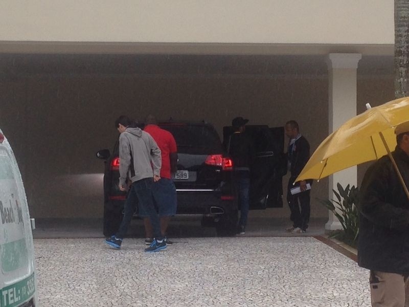 De boné, ao lado do pai, Neymar entra no carro caminhando normalmente nesta quinta-feira, no Guarujá