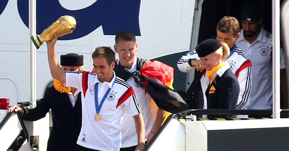 Alemão Philipp Lahm exibe a taça da Copa do Mundo no desembarque do time em Berlim