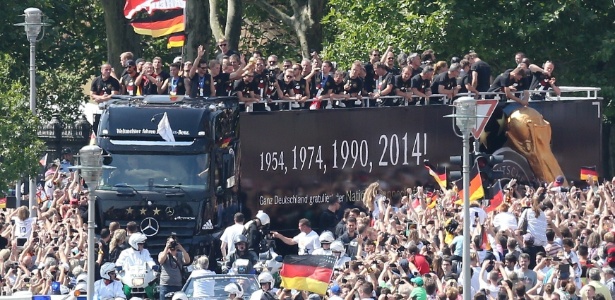 Torcedores fazem festa durante passagem do ônibus com os jogadores da seleção da Alemanha em Berlim - AFP PHOTO / DPA / WOLFGANG KUMM