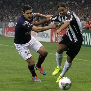 23.jul.2014 - Ronaldinho Gaúcho é puxado por Gustavo Portillo, do Lanús, na final da Recopa - REUTERS/Washington Alves