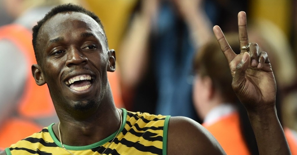 Usain Bolt acena após vencer com a Jamaica eliminatória do revezamento 4x100 m no Jogos da Comunidade Britânica