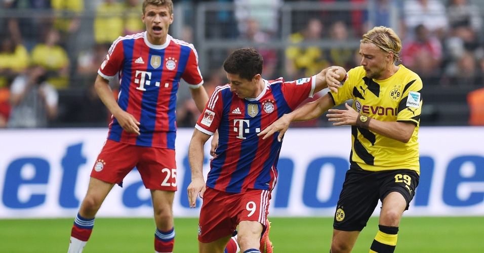 Agora atacante do Bayern de Munique Robert Lewandowski tenta se livrar da marcação do Borussia Dortmund, sua ex-equipe, na Supercopa da Alemanha