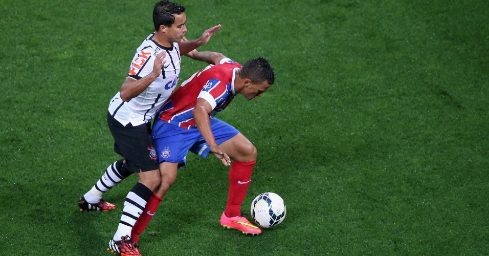 16.ago.2014 - Jadson (e), do Corinthians, aperta a marcação sobre Raul, do Bahia, durante jogo do Brasileirão