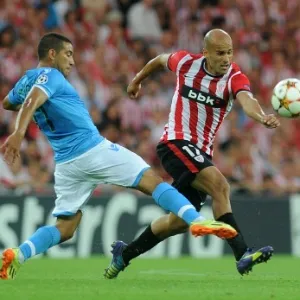 27. ago. 2014 - Meia do Athletic Bilbao Mikel Rico sofre a falta do uruguaio Walter Gardano, do Napoli, na partida entre as equipes, pela Liga dos Campeões - AFP PHOTO / RAFA RIVAS