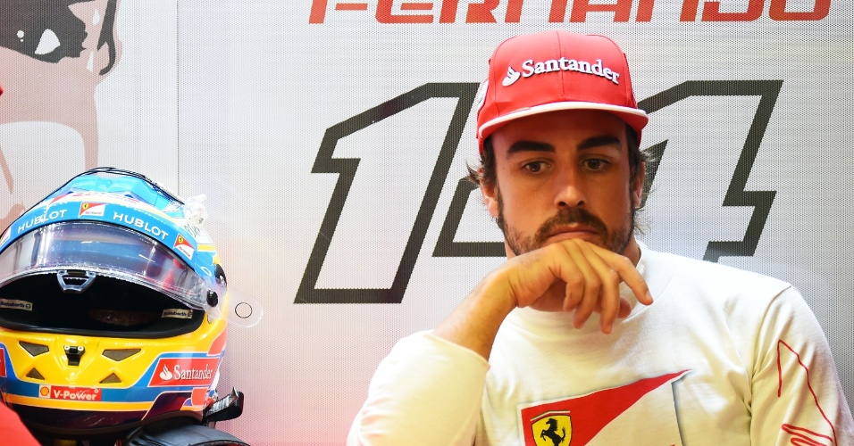 20.set.2014 - Fernando Alonso relaxa no box da Ferrari antes de tentar uma volta rápida no circuito de Marina Bay no treino de classificação para o GP de Cingapura