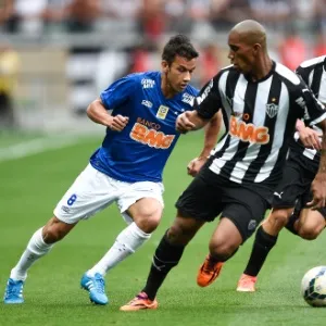 Henrique, do Cruzeiro, tenta passar por Emerson Conceição e Carlos, do Atlético-MG - Pedro Vilela/Getty Images
