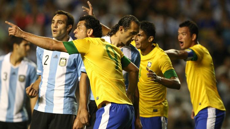 Durval (centro da foto) vigia os passos do argentino Hernan Barcos. Zagueiro defendia o Santos quando recebeu chamado para disputar o Superclássico das Américas em 2012