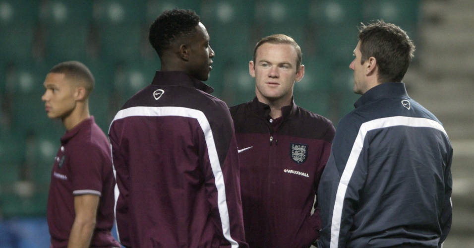Rooney, atacante da Inglaterra, conversa com Welbeck (à esquerda) e um membro da comissão técnica no reconhecimento de gramado na Estônia; time entra em campo no domingo