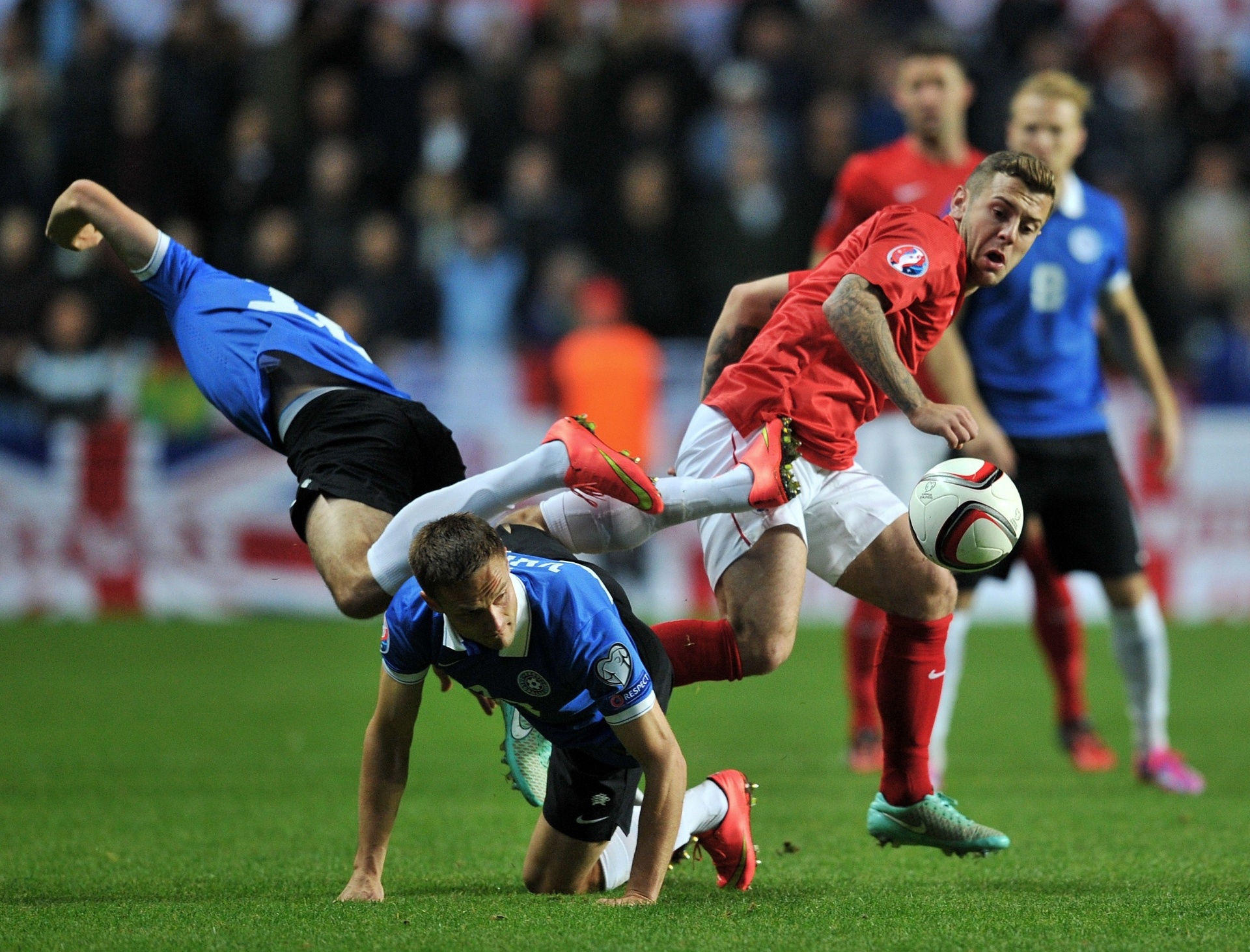 Jogadores de Inglaterra e Estônia se enroscam durante confronto válido pelas Eliminatórias da Euro 2016 - AFP PHOTO / GLYN KIRK