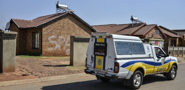 Polícia investiga evidências no local do crime, na região metropolitana de Johanesburgo - AFP PHOTO / MUJAHID SAFODIEN
