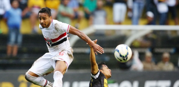 Alvaro Pereira salta para tentar evitar carrinho de jogador do Criciúma contra o São Paulo - Cristiano Andujar/Getty Images