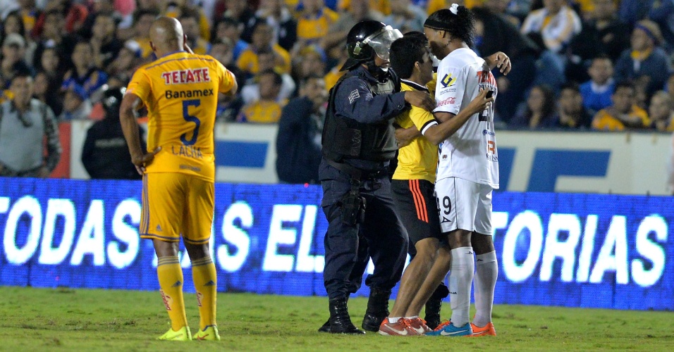 Ronaldinho é abraçado por invasor durante partida do Campeonato Mexicano em que seu time, o Querétaro, perdeu para o Tigres por 1 a 0