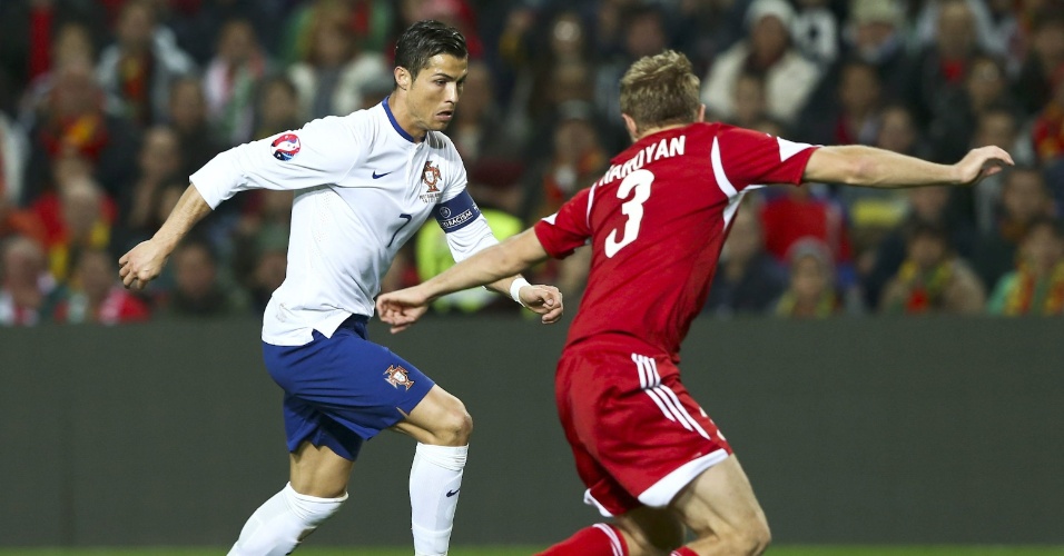 Português Cristiano Ronaldo encara marcação de Varazdat Haroyan, da Albânia, em jogo do Grupo I