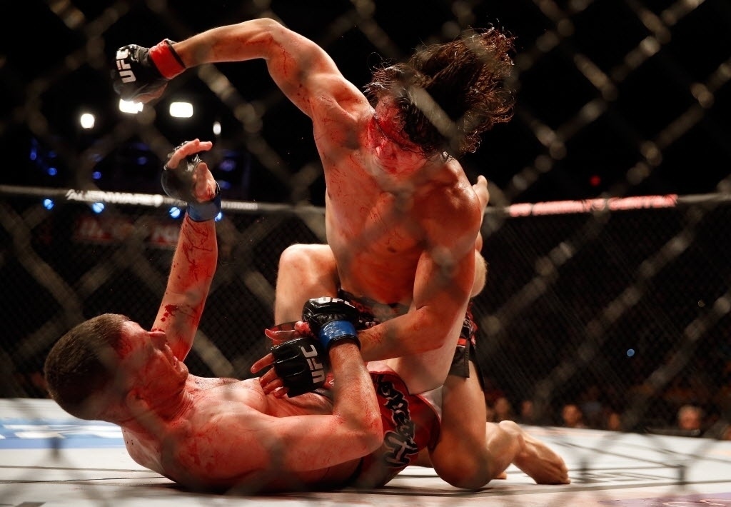 13.dez.2014 - David Michaud encaixa golpes em Garett Whiteley no ground and pound; luta foi bastante sangrenta por causa de um corte no supercilio de Michaud, que mesmo assim venceu por decisão unânime dos juízes - Christian Petersen/Getty Images/AFP