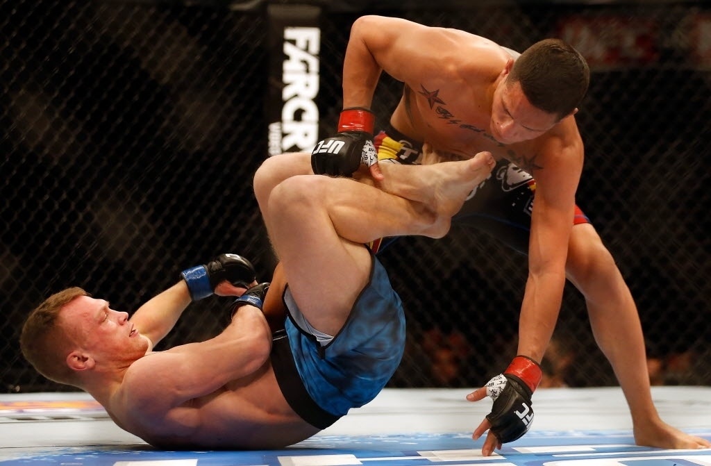 13.dez.2014 - Ian Entwistle encaixa uma chave na perna de Anthony Birchak logo no início do primeiro round da luta, a primeira da noite no UFC: Cigano x Miocic - Christian Petersen/Getty Images/AFP