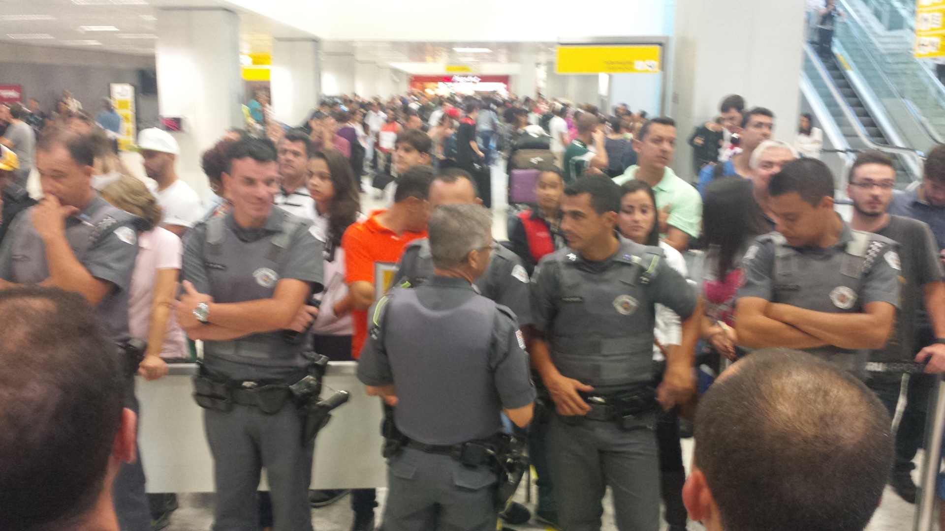 A Polícia Militar armou um forte esquema de segurança para recepcionar o brasileiro Gabriel Medina. Os policiais fizeram um cordão de isolamento no aeroporto de Guarulhos - Fábio Aleixo/UOL