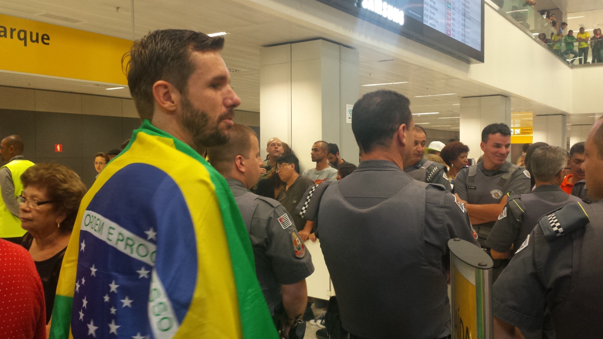 Muitos fãs foram ao aeroporto de Guarulhos na tarde desta terça-feira para recepcionar o brasileiro Gabriel Medina, atual campeão mundial de surfe. Um dos torcedores usou uma bandeira do Brasil para homenageá-lo - Fábio Aleixo/UOL