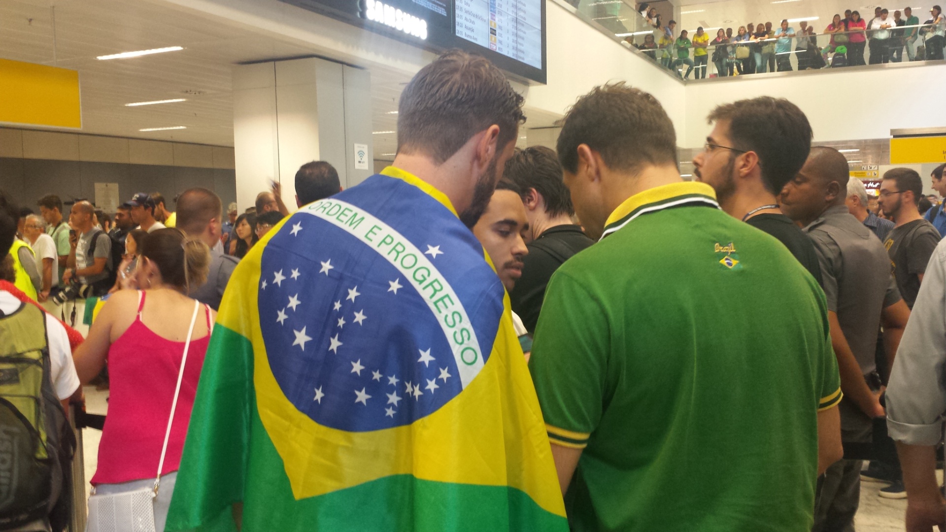 Muitos fãs foram ao aeroporto de Guarulhos na tarde desta terça-feira para recepcionar o brasileiro Gabriel Medina, atual campeão mundial de surfe. Um dos torcedores usou uma bandeira do Brasil para homenageá-lo - Fábio Aleixo/UOL