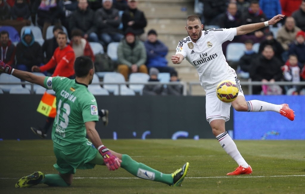 18.jan.2015 - Benzema, atacante do Real Madrid, chuta bola contra Jordi Codina, goleiro do Getafe, em partida do Campeonato Espanhol neste domingo (18) - Sergio Perez/REUTERS