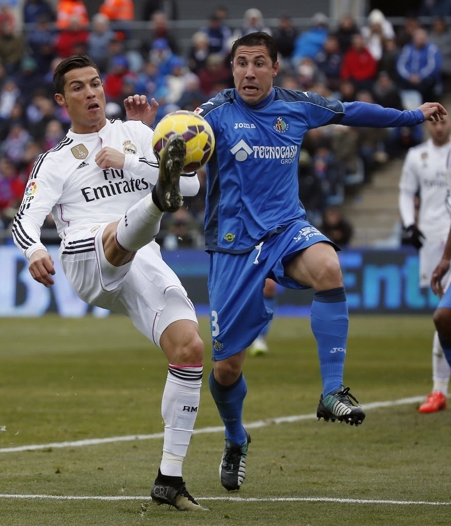 18.jan.2015 - Cristiano Ronaldo disputa bola com Roberto Lago, do Getafe, durante partida do Campeonato Espanhol neste domingo (18)