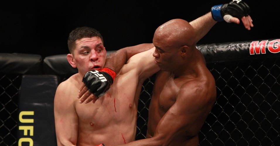 Com o rosto machucado, Nick Diaz tenta se livrar da investida de Anderson Silva durante a luta principal do UFC 183 em Las Vegas (EUA)