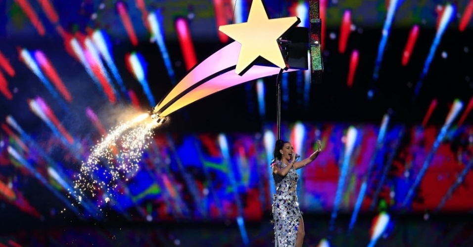 Com fogos de artifício ao fundo, Katy Perry sobrevoa o estádio de Glendale, no Arizona, cantando Firework no show do intervalo do Super Bowl 49