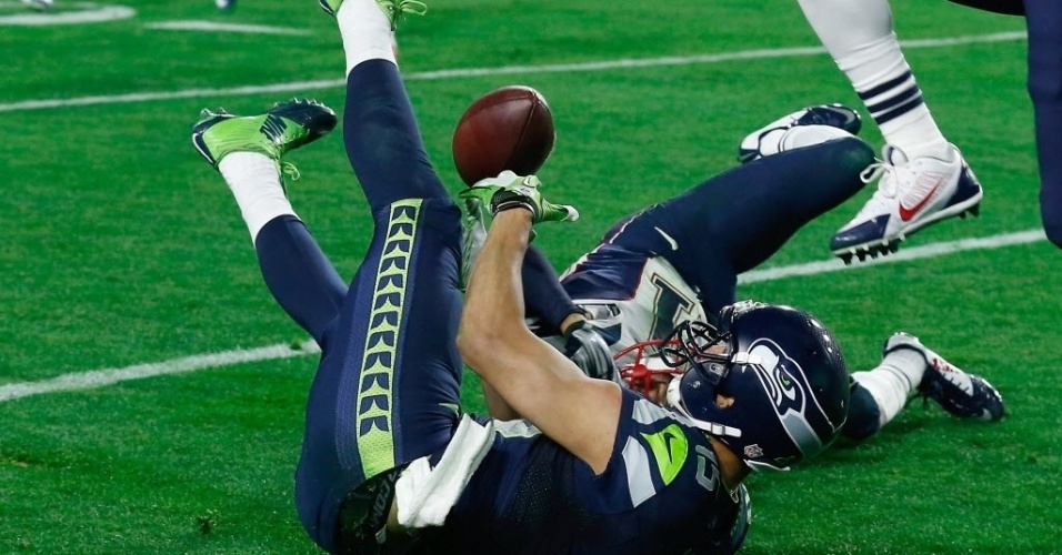 Jermaine Kearse, wide receiver do Seattle Seahawks, solta a bola no ar enquanto cai, mas ainda consegue receber o passe