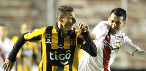 Escobar (frente) disputa bola com Arreola durante o jogo entre Strongest x Morelia pela Libertadores - AIZAR RALDES / AFP