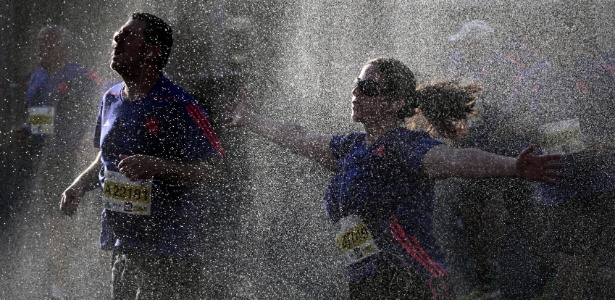 Corredores da Maratona de Tel Avviv recebem banho de água por causa do forte calor - Abir Sultan/EFE