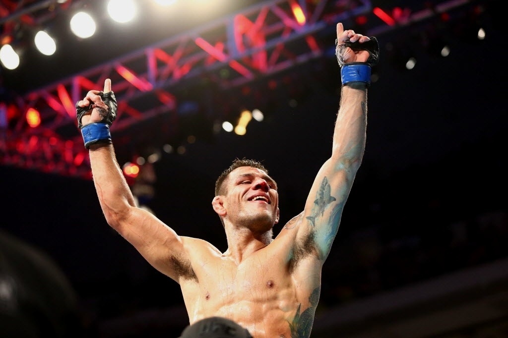 Rafael dos Anjos comemora após se tornar o novo campeão dos leves do UFC; brasileiro derrotou Anthony Pettis por decisão unânime dos juízes - Ronald Martinez/Getty Images/AFP
