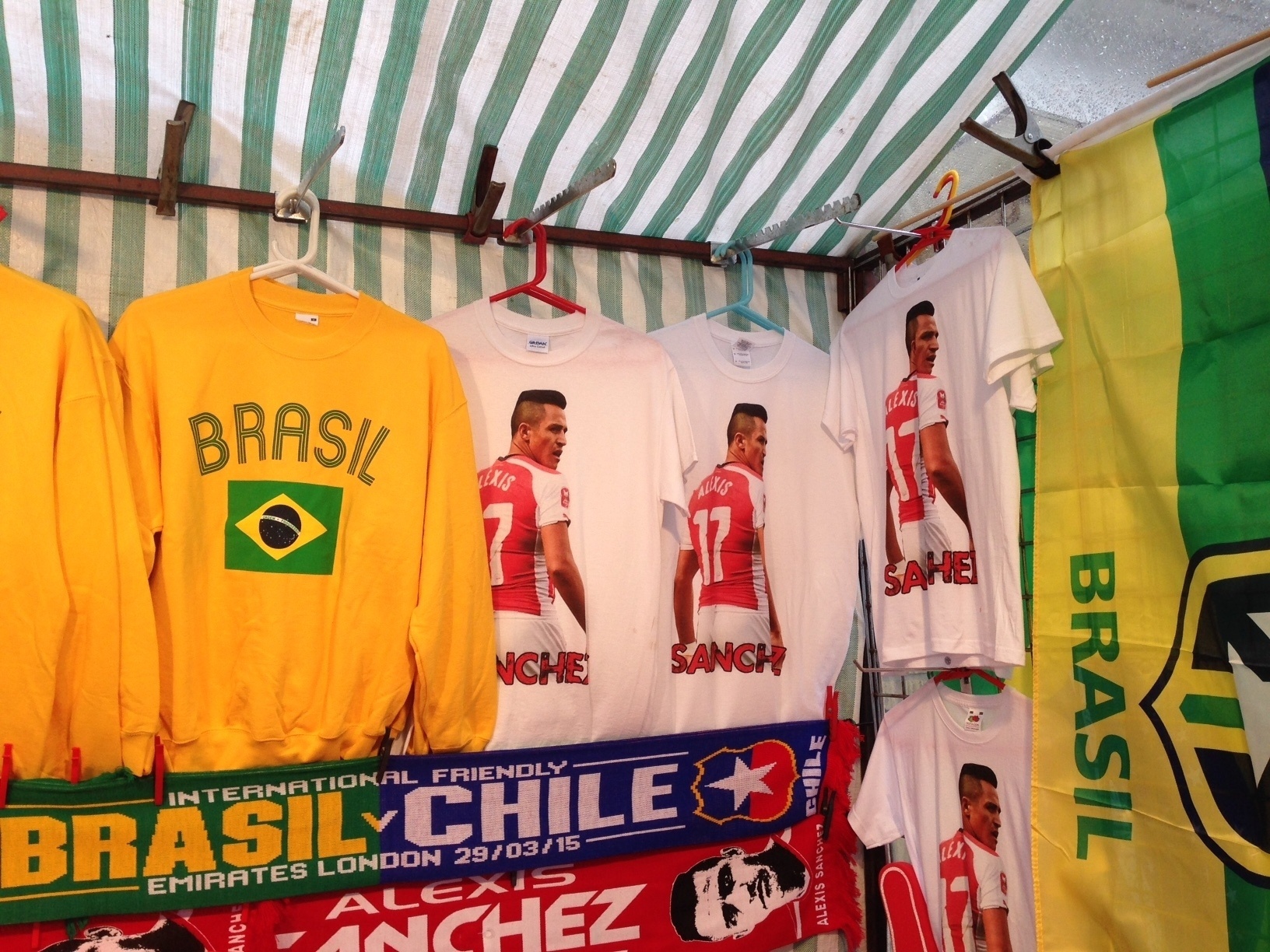 29.mar.2015 -Camisetas de Alexis Sánchez dividem espaço com itens da seleção brasileira nos arredores do Emirates Stadium - João Henrique Marques/UOL