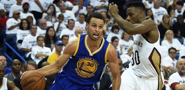 Stephen Curry se livra da marcação de Norris Cole durante a partida entre Golden State Warriors e New Orleans Pelicans - Stacy Revere/Getty Images