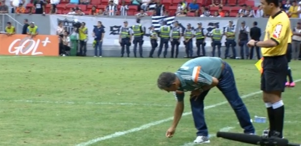 Ricardo Drubscky recolhe as moedas arremessadas durante a goleada sofrida para o Atlético-MG - Reprodução TV/Premiere