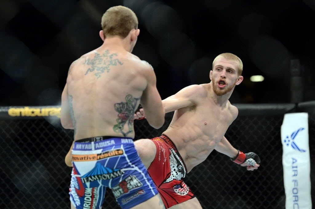 Justin Scoggins (dir.) acerta chute alto em Josh Sampo; Scoggins venceu a primeira luta do UFC 187, por decisão unânime dos juízes, neste sábado (23) - Joe Camporeale/USA TODAY Sports