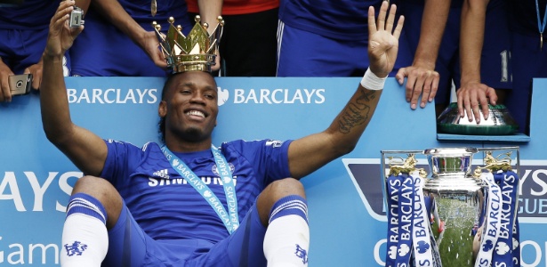 Jogadores do Chelsea retiram coroa da taça e colocam na cabeça de Didier Drogba - ADRIAN DENNIS / AFP