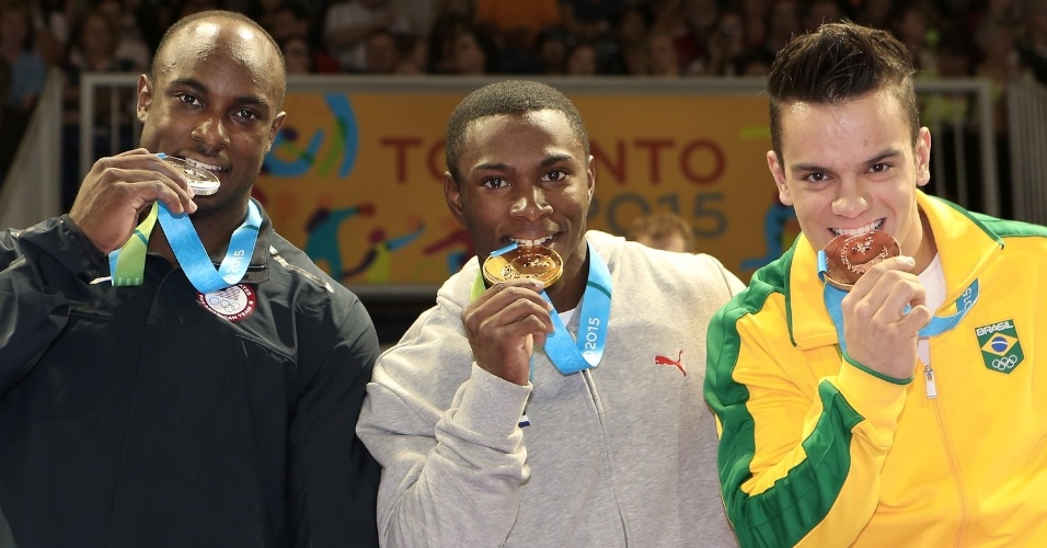 Ao lado do americano Donnell Whittenburg e do cubano Manrique Larduet, prata e ouro, respectivamente, Caio Souza morde a medalha de bronze conquistada no salto sobre a mesa