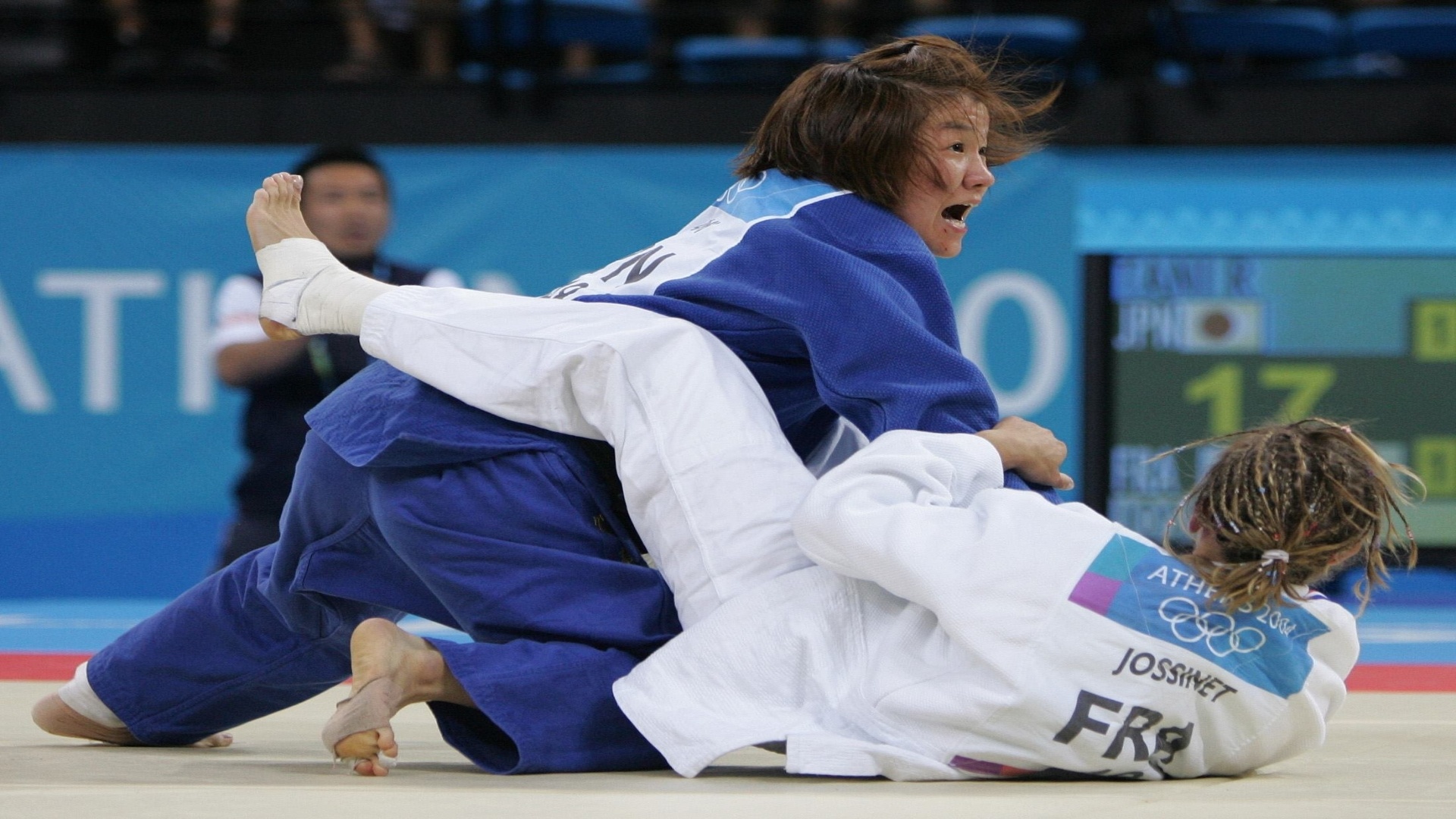 14.ago.2004 - Japonesa Ryoko Tamura Tani aplica um golpe na francesa Frederique Jossinet na disputa do judô na Olimpíada de Atenas
