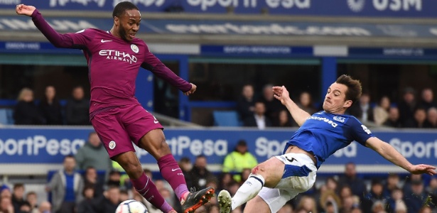 Sterling chuta para anotar o terceiro gol do City contra o Everton - Paul Ellis/AFP - Paul Ellis/AFP