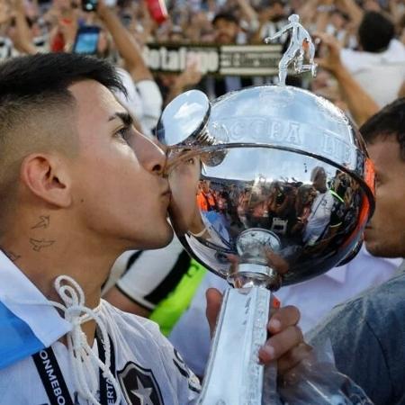 Almada beija a taça da Libertadores com a bandeira argentina nas costas