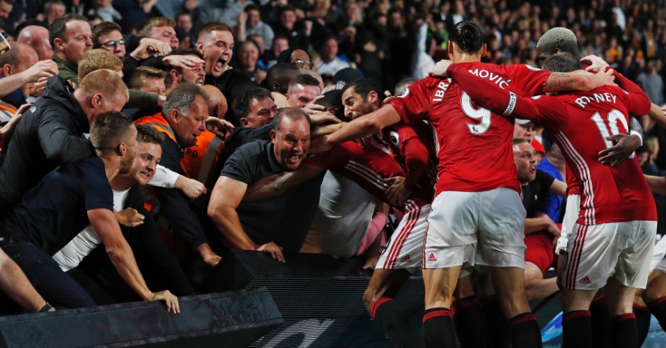 Torcedores e jogadores do Manchester United comemoram gol marcado no último minuto